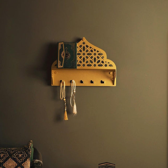 Decorative wall shelf with intricate design on a dark wall, next to a green sofa and decorative mirror.