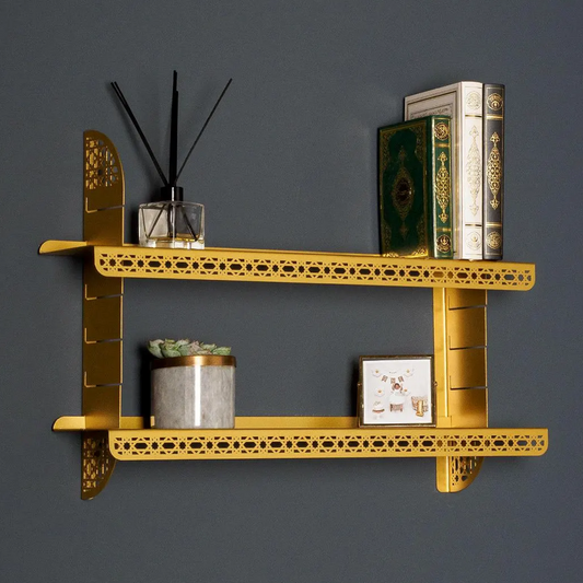Gold decorative shelf with various items against a dark gray wall